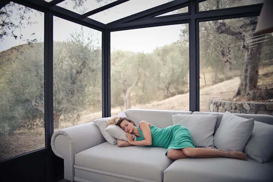 woman sleeping on sofa near newly replaced glass windows